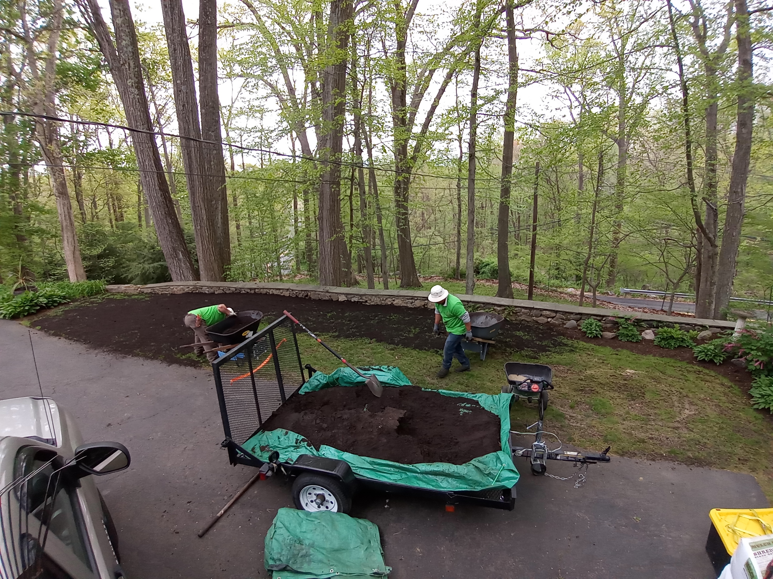 OWM crew in green shirts spreading rich organic compost from a trailer onto a garden bed